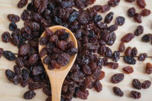Сушените плодове – полезни или не толкова? - raisins on a wooden spoon