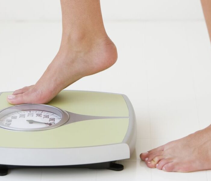 Защо се връщат свалените килограми? - woman stepping on scale royalty free image 81896517 1542806626