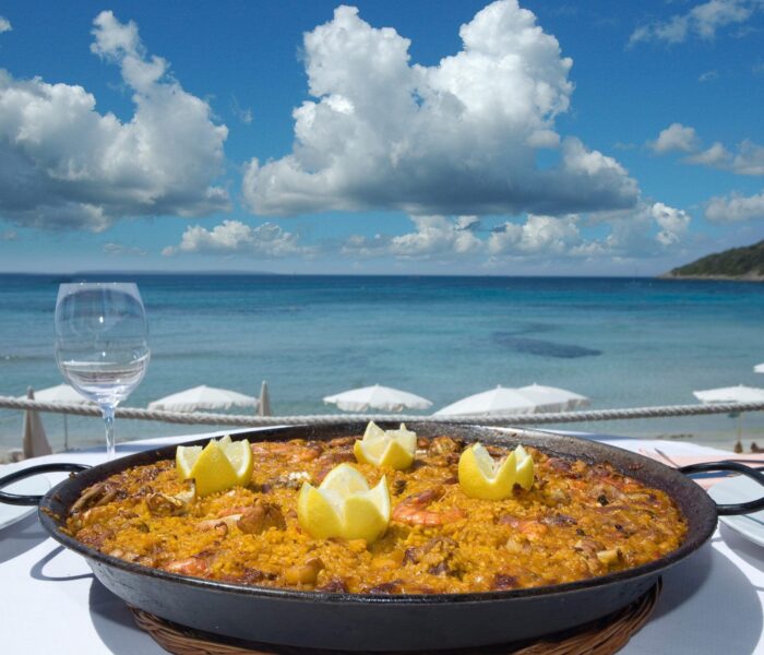 tray of Spanish paella on the sea background