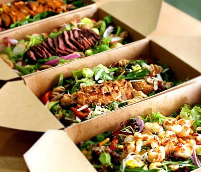 several chicken salads in cardboard boxes