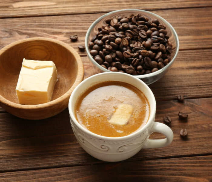 Composition with tasty butter coffee on wooden table